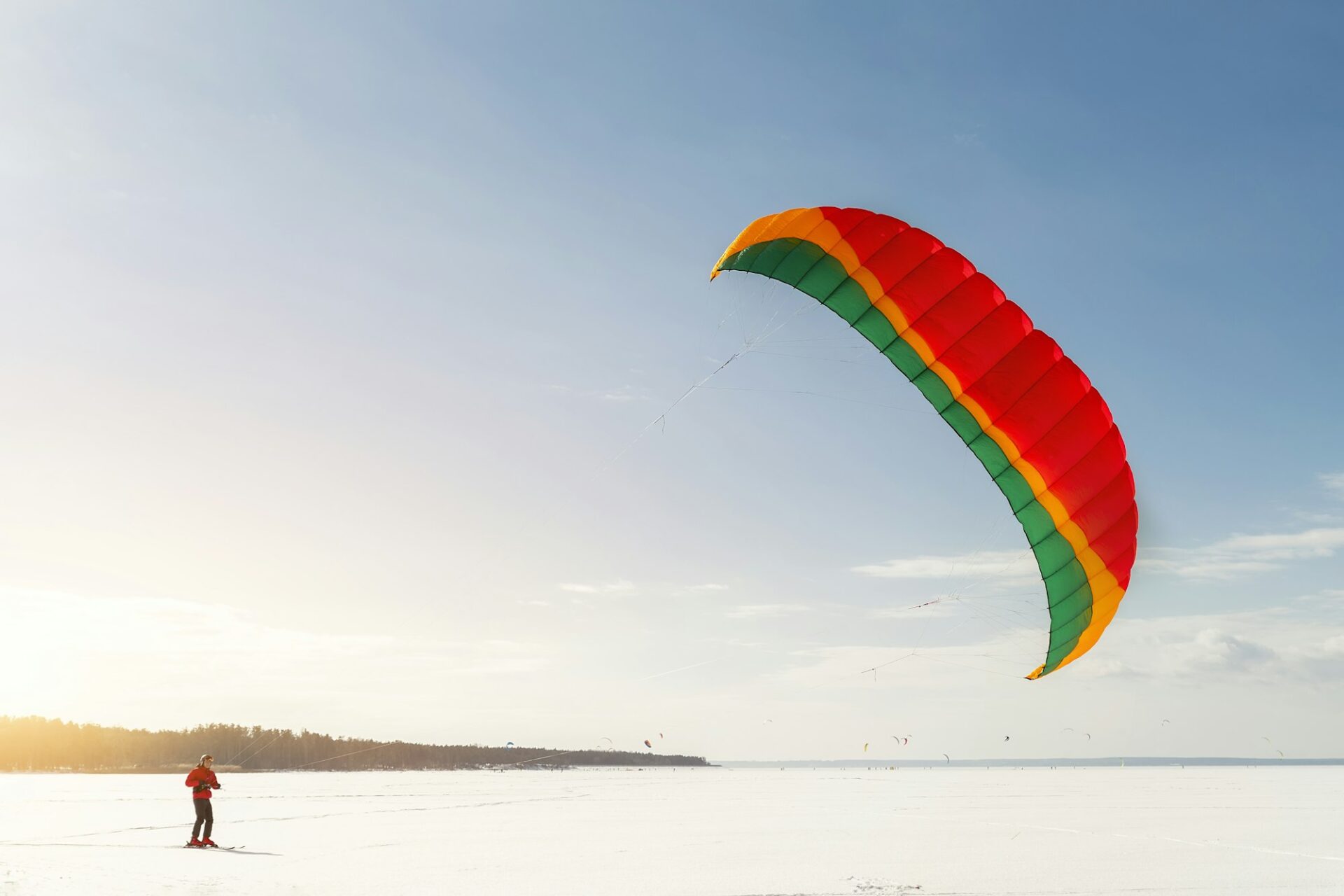 Panoramic view of many people friends enjoy riding kite surf board in warm suit on bright sunny